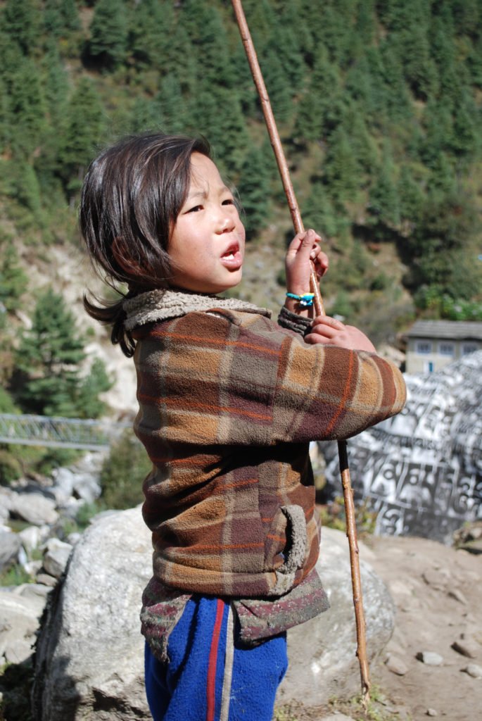 Ett barn leker intill stigen till Everest Base Camp