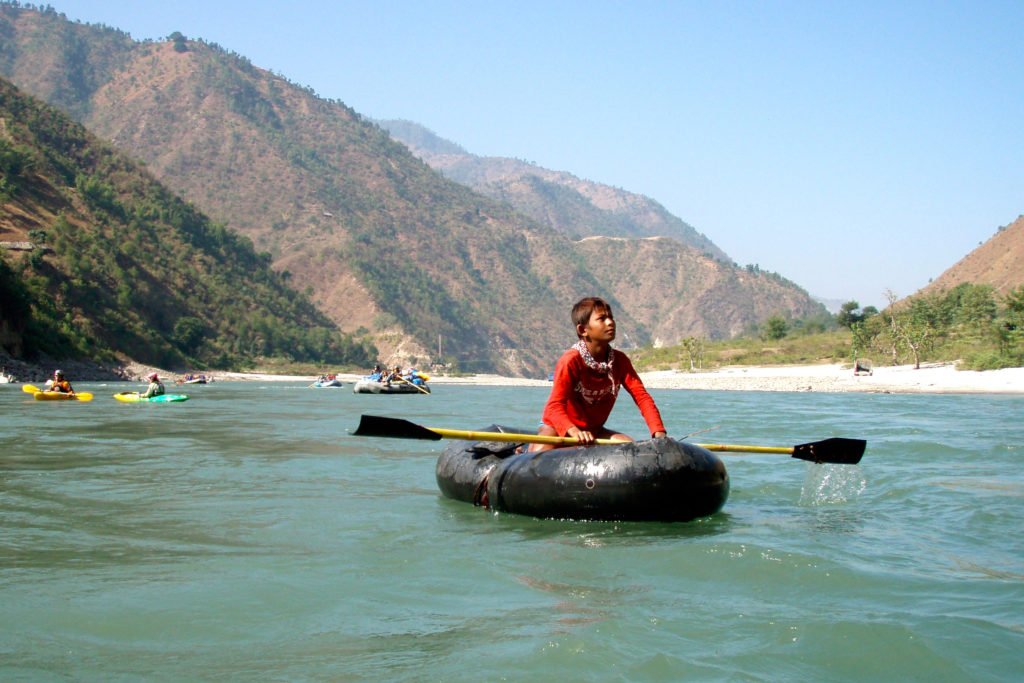 Forspaddling Nepal, ung pojke paddlar en hemmagjord kajak