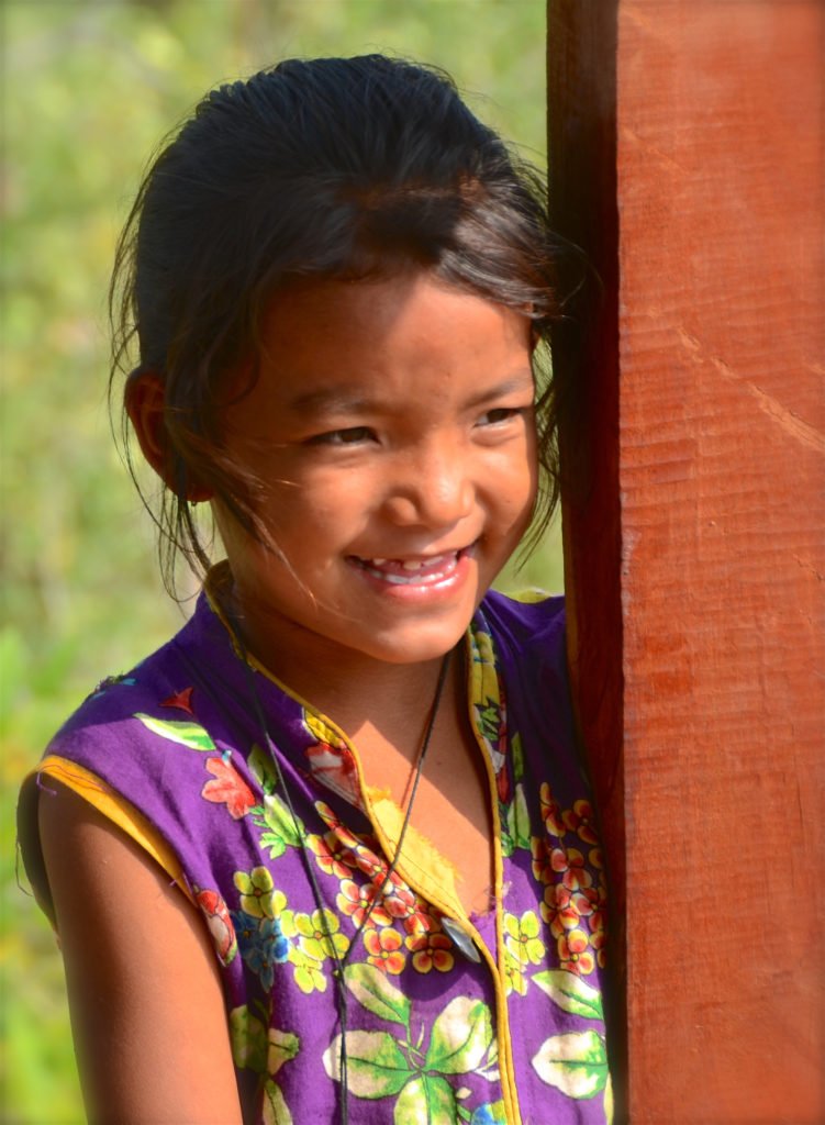 Tjejresa Nepal, en glad flicka betraktar passerande turister