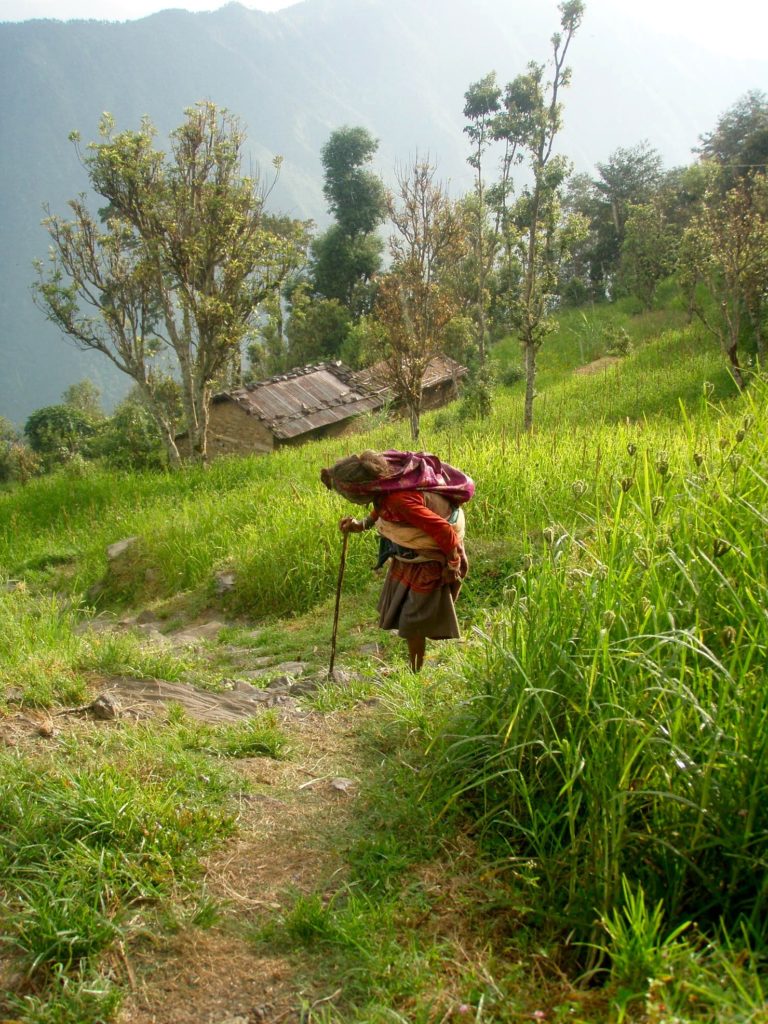 Annapurna Base Camp, em gammal dam med käpp på väg upp för en stig