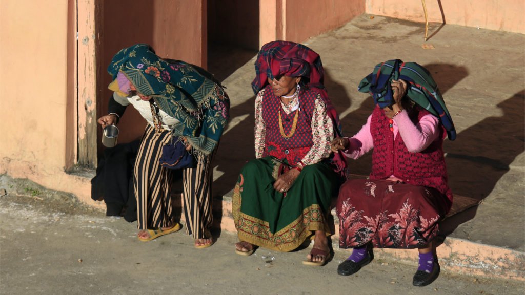 några bybor sitter och vilar sig i en by i Annapurnabergen
